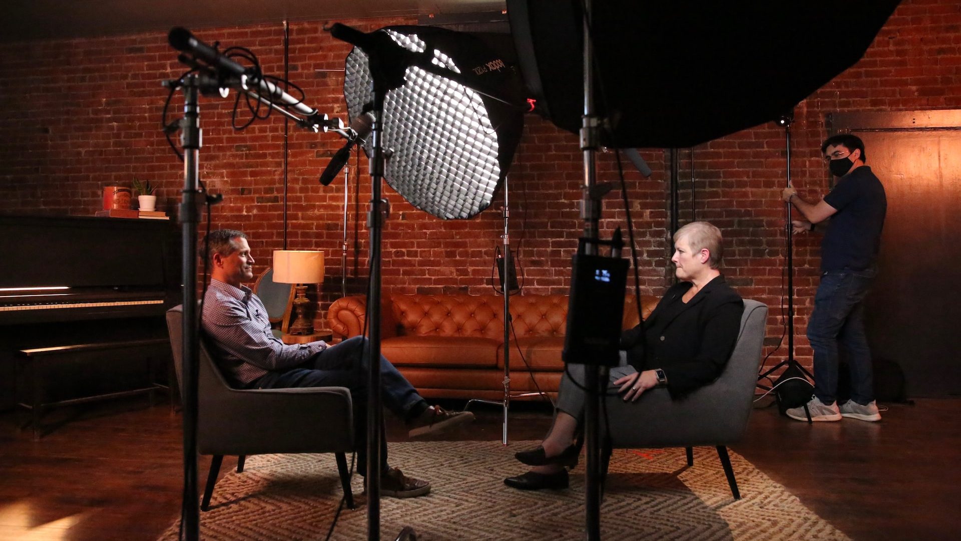 a man and a woman sitting in chairs in front of a camera